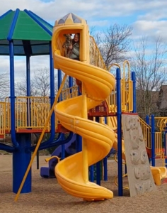 yellow curly slide a girl and dog at the top